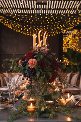 Christmas table with candles, flowers and fruits