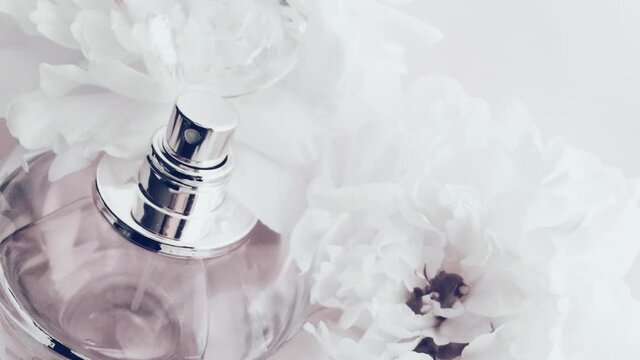 White perfume bottle with peony flowers, chic fragrance scent as luxury cosmetic, fashion and beauty product background, stock footage