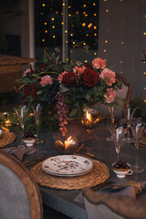 Christmas table with candles, flowers and fruits