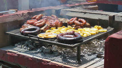 Foto de un típico asado de carne, chorizo y morcilla a la brasa con carbón. 