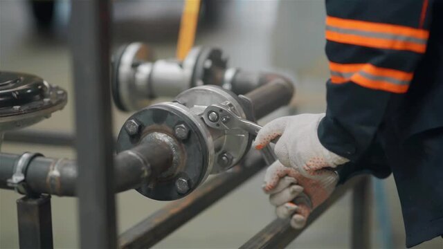 closeup of a hand with a wrench tighten the nut