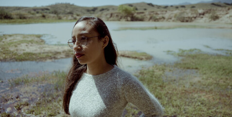 woman with glasses and sweater in a lake