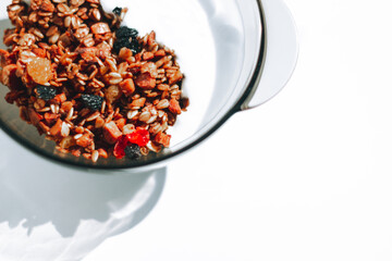 Homemade granola with berries and yogurt for breakfast on the white background, close-up, top view, horizontal