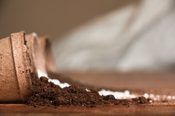 Peat moss coming out of a peat pot with perlite and worm humus as substrates for potting soil mix in the background, copy space for text.