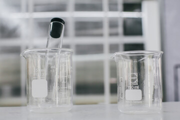 Beaker and test tubes in chemistry science laboratory background. Laboratory glassware for research and development concept.