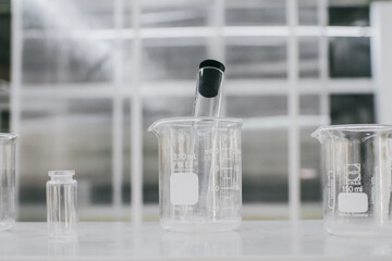 Beaker and test tubes in chemistry science laboratory background. Laboratory glassware for research and development concept.