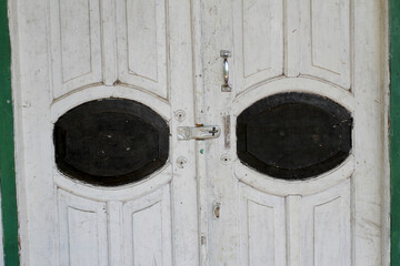 Old wooden door with dull white and black paint
