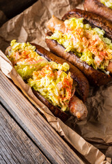 Healthy and tasty hot-dog with big grilled sausage, fresh green cabbage and sauce. Selective focus. Shallow depth of field.