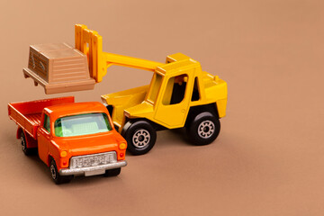 Fototapeta na wymiar forklift putting load on a truck - miniature metal toys