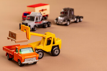 forklift loading a truck and three trucks in the background - miniature metal toys