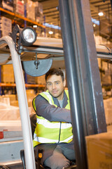Portrait male worker driving forklift in distribution warehouse © Paul Bradbury/Caia Image