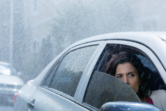 Concerned woman driving car in rain