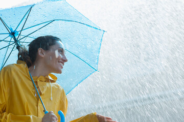 Rain falling over smiling woman with umbrella © Martin Barraud/Caia Image