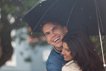 Happy young couple with umbrella in rain © Sam Edwards/Caia Image