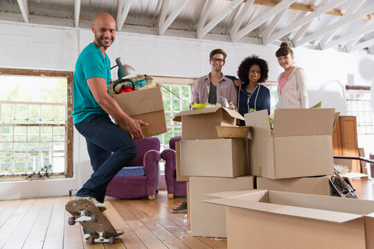 Portrait happy young roommates moving into loft apartment