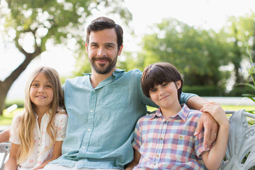 Fototapeta premium Portrait happy father and children on bench
