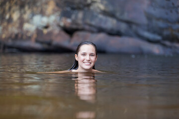 Fototapeta premium Portrait smiling young woman swimming in lake