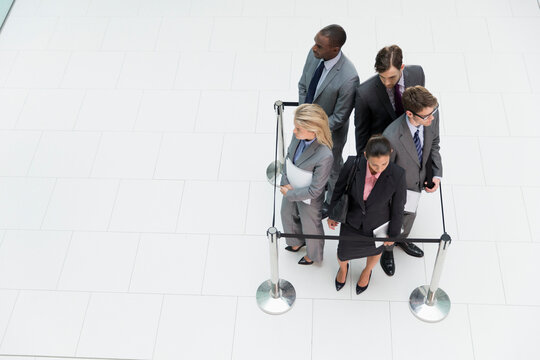 Business people trapped in square stanchions