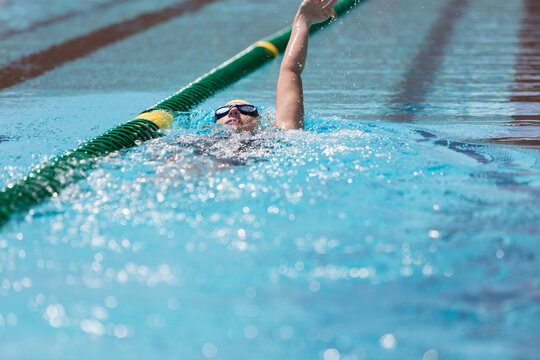 Female swimmer practicing backstroke in swimming pool