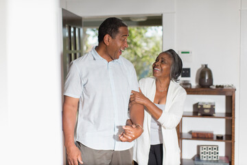 Obraz premium Happy senior couple holding hands at home