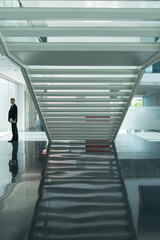 Obraz premium Businessman in modern lobby with staircase