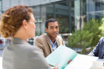 Fototapeta premium Business people discussing paperwork outside