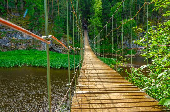 A wooden suspension bridge spanned the river.
