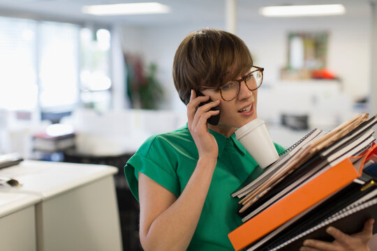 Overwhelmed businesswoman multitasking in office