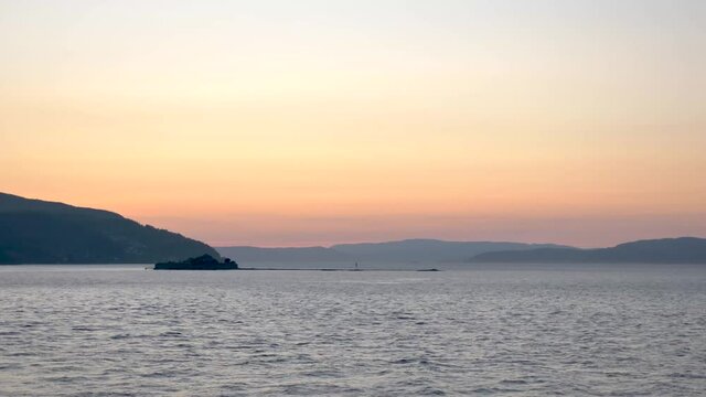 Sunset at sea with an ancient monastery island Munkholmen in foreground Norway