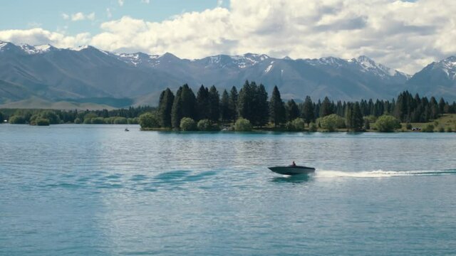 Boat speeding on beautiful mountain lake