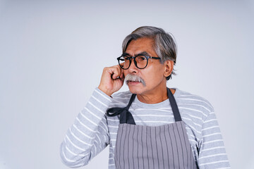 Thoughtful old elderly senior man wear eyeglasses and apron isolate on white.