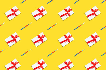 Fototapeta na wymiar Repetitive creative pattern of Christmas holiday present with syringe on yellow background