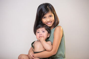 Mexican siblings  girl and  baby boy  isolated smiling wearing green clothes