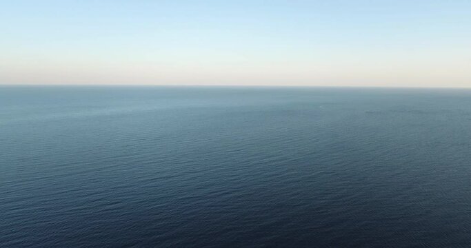 Calm sea horison background texture with small wave and clear sky / aerial fast speed drone shot at summer morning view