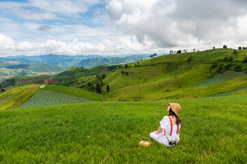 Fototapeta na wymiar Young woman feel relaxing on green grass mountain