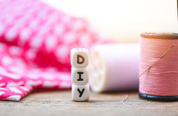 diy thread and needle on wooden table - bobbins with thread and needles, striped fabric Old sewing...