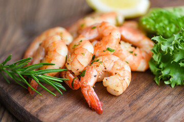 Salad shrimp grilled delicious seasoning spices on wooden cutting board background appetizing cooked shrimps baked prawns Seafood shelfish with rosemary lemon and lettuce