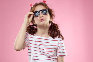 Cheerful girl with pigtails sunglasses striped t-shirt lifestyle pink background