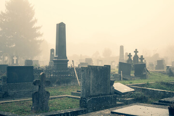 Old cemetery grave covered in autumn mist or fog as All Saints Day, All Souls Day, helloween or...