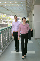 Obraz premium Young south east Asian middle eastern man woman business office outdoor walk in corridor follow