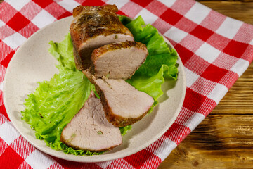 Tasty baked pork with spices on a wooden table