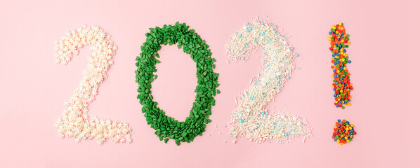 New year 2021 made of candy sprinkles for seasonal holiday cookies on pink pastel background, banner for promotion culinary shop and master classes