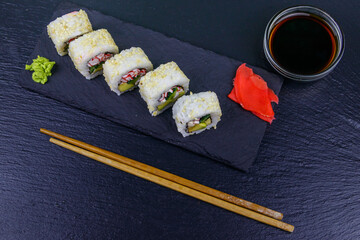 Uramaki sushi rolls with surimi on a black slate