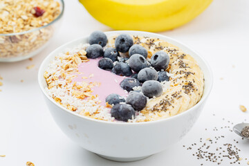 Berry smoothie Breakfast in a bowl with banana, yogurt, blueberries, granola and Chia seeds.