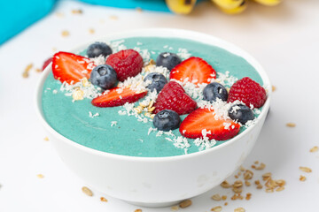 Smoothie bowl with fresh berries, bananas, muesli, blue tea and coconut yogurt.