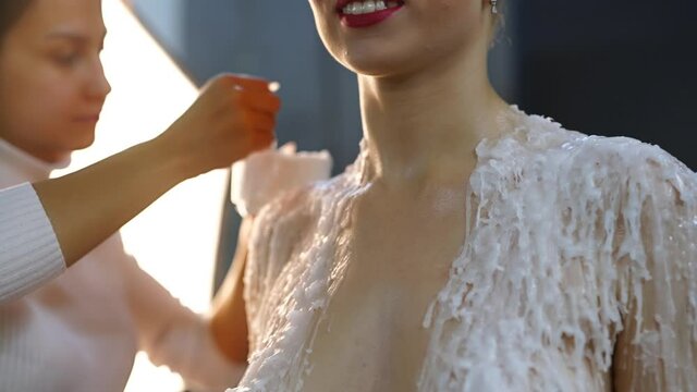 Visagist pouring liquid paraffin on model