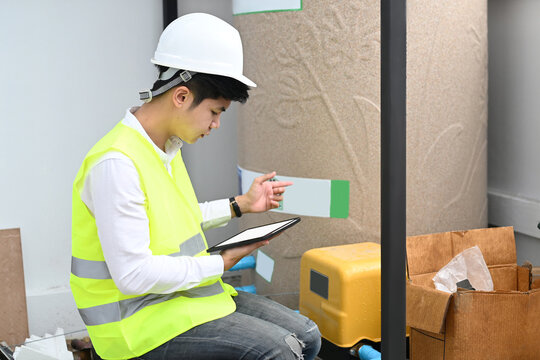 Young engineer using tablet while sitting at construction site project.