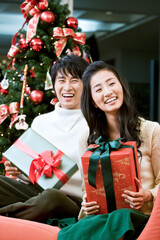 young man and woman with the Christmas tree and gift boxes