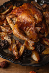 Close-up view of baked turkey stuffed with apples served with potato on black dish. Festive diner for thanksgiving day. Tasty meal. Food holiday concept.