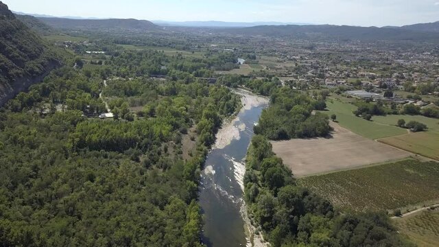 Cliffs overlook Ardeche River, vineyards and orchards in rural France